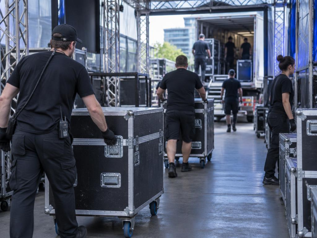 Equipe de logística transportando cases e equipamentos nos bastidores